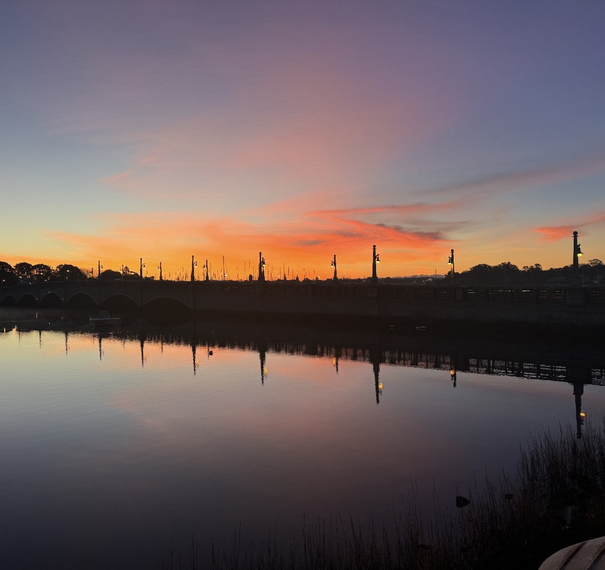 harbor at sunset with orange, gray and blue sky